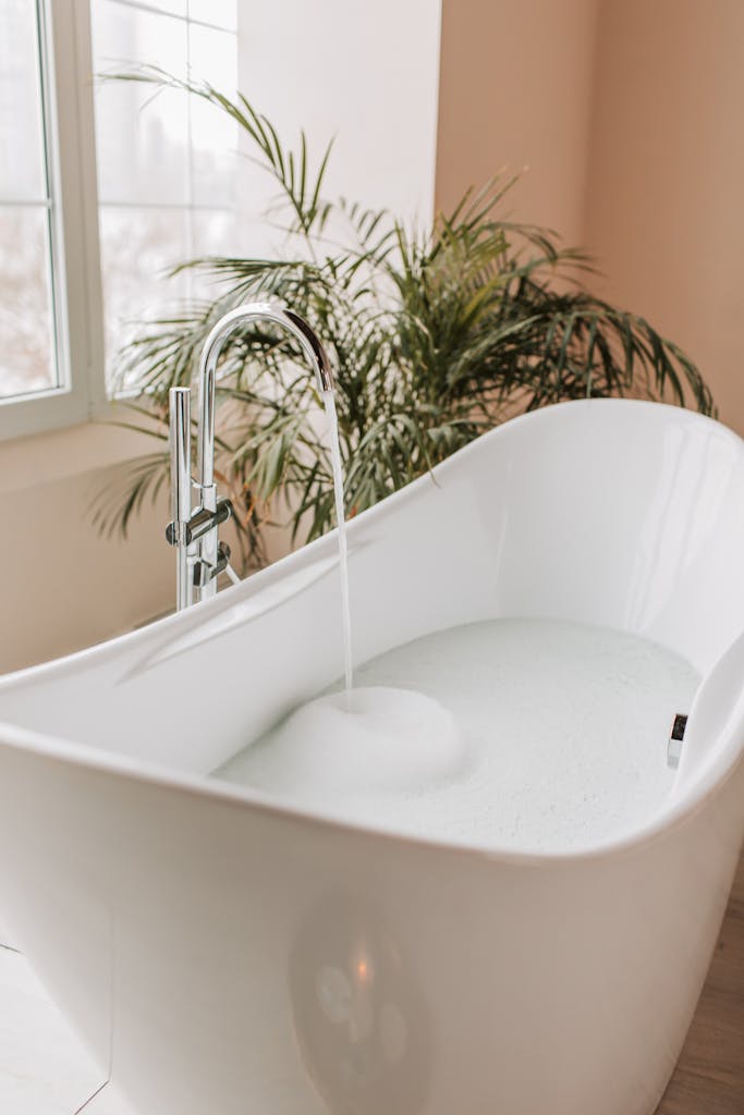 White kidney shaped bathtub with chrome faucet