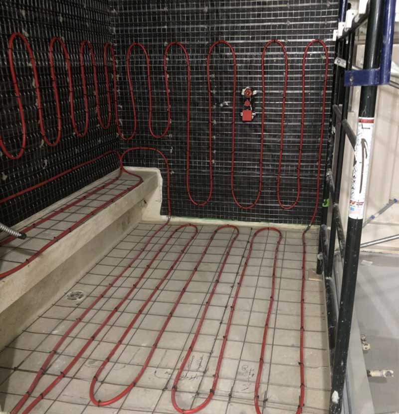 Radiant heat tubing on floor, bench, and walls of shower.